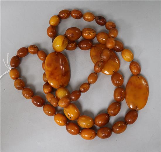 A single strand amber bead necklace, strung with oval and flat beads, gross weight, 109 grams, 98 cm.
